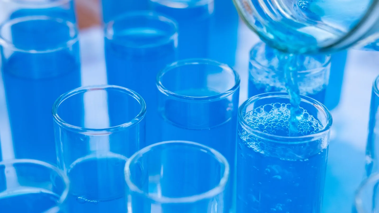 Probengefäße mit blauer Flüssigkeit im Labor